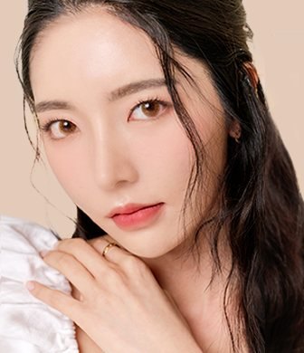긴 머리 여성 모델이 어깨에 손을 올린 모습(흰 블라우스, 분홍 베이지 배경)